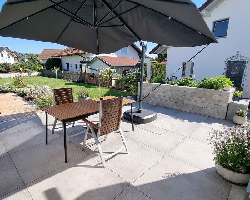 Aufnahme einer gefplasterten Terrasse mit Sitzplatz und Sonnenschirm