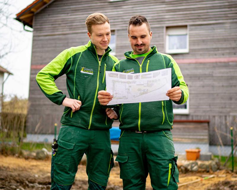 Simon Schmid und ein Angestellter beraten über die Pläne zum neuen Kundenprojekt