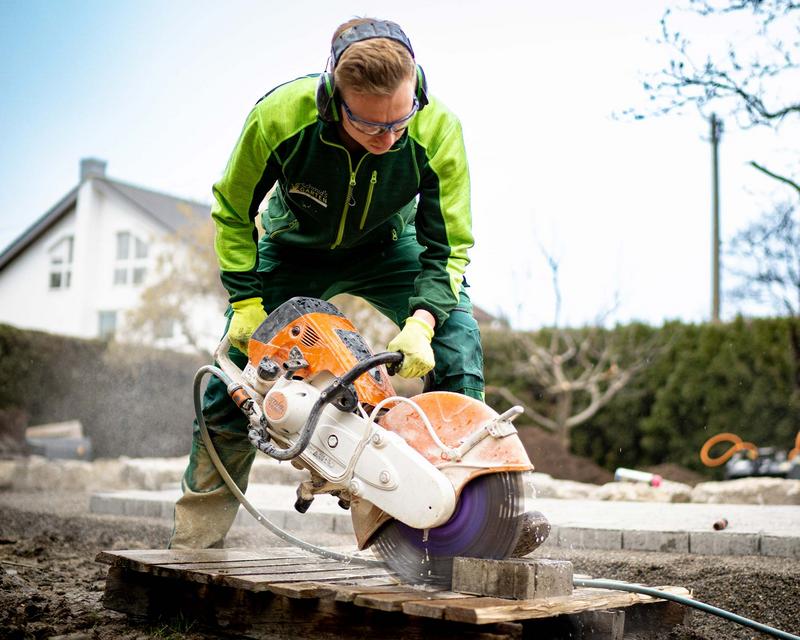 ein Mitarbeiter von Schmids Garten bei der Arbeit mit einer Steinsäge