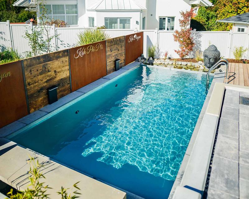 großer türkiser Biopool in einem Garten