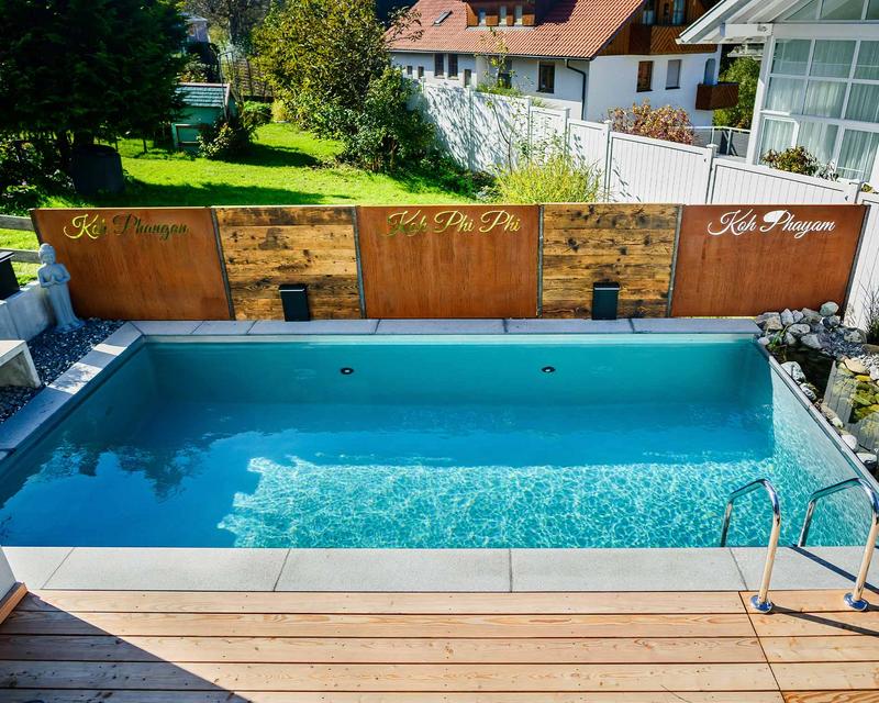 türkiser Biopool mit abwechselnden Sichtschutzelementen aus Holz und Metall