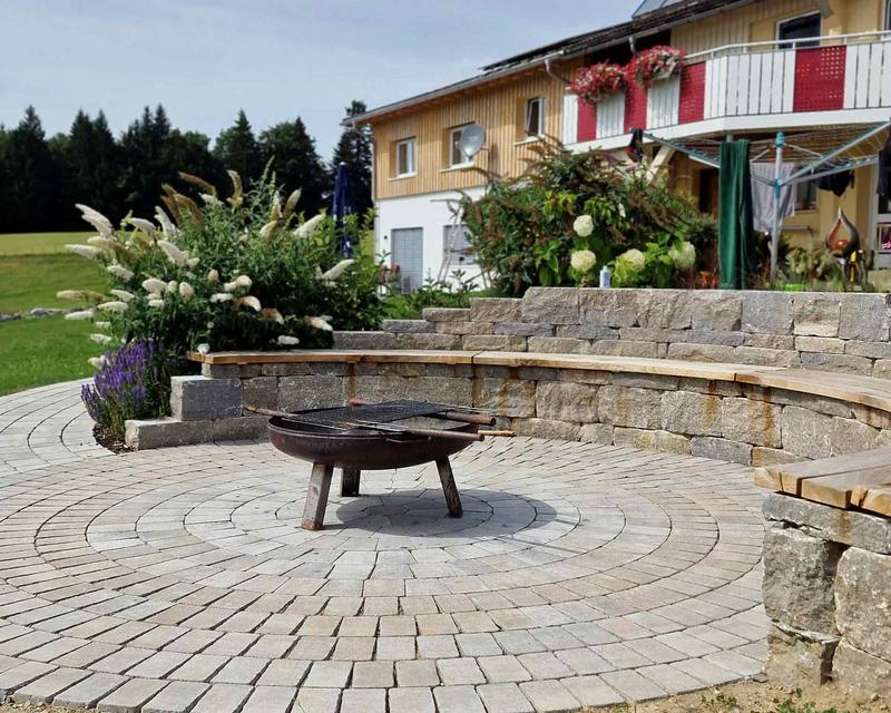 gepflasterter Grillplatz mit runder Mauer und Sitzbank