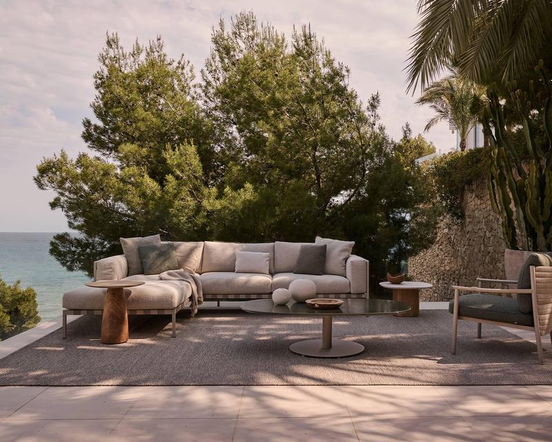 hochwertige Gartenlounge mit Sitzkissen auf einer schattigen Terrasse