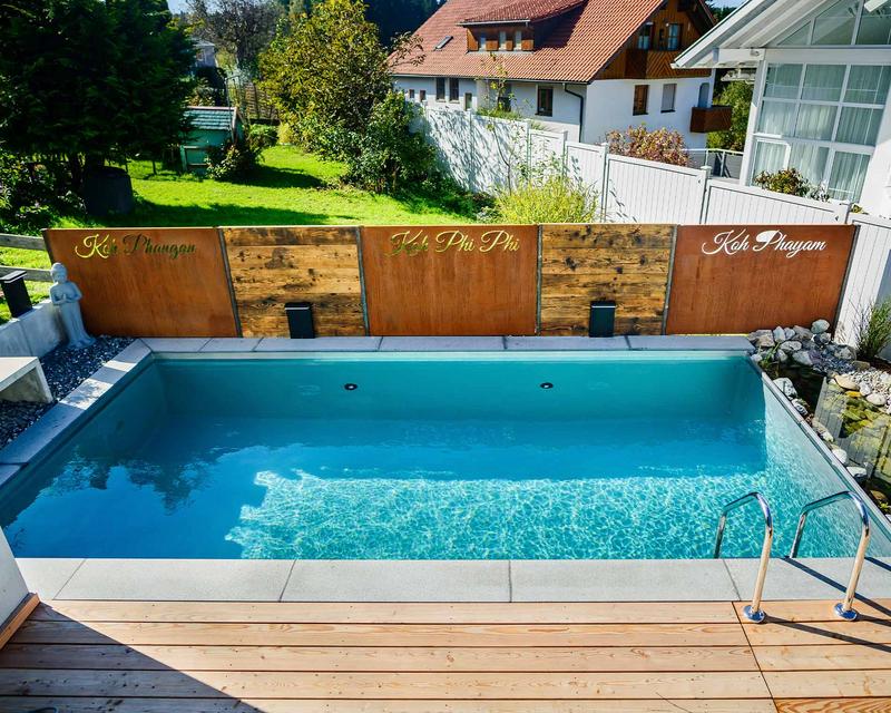 Aufnahme eines türkisenen Biopools in einem Familiengarten