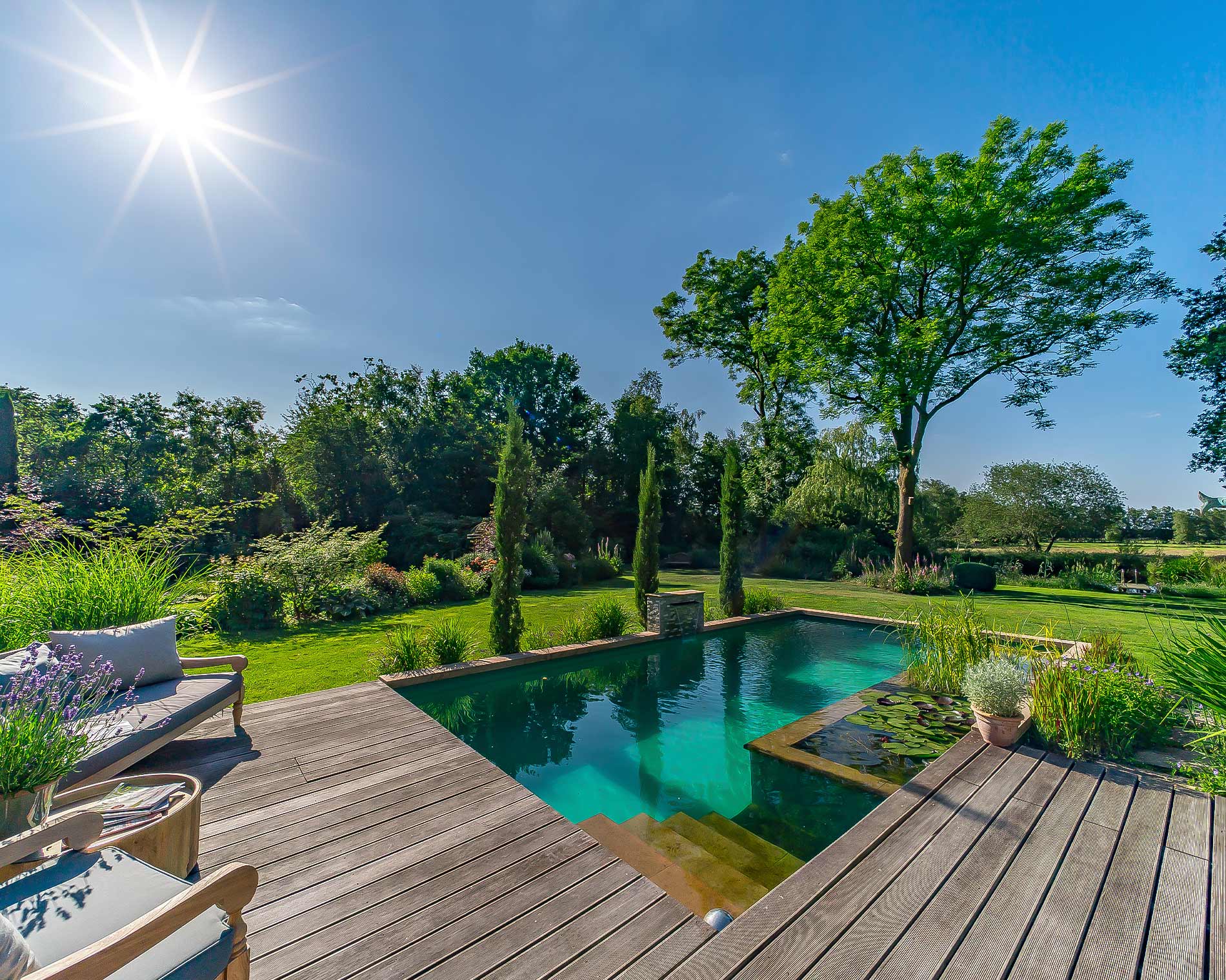 sonniger Garten mit schönem Naturpool, Holzterrasse und Loungebereich