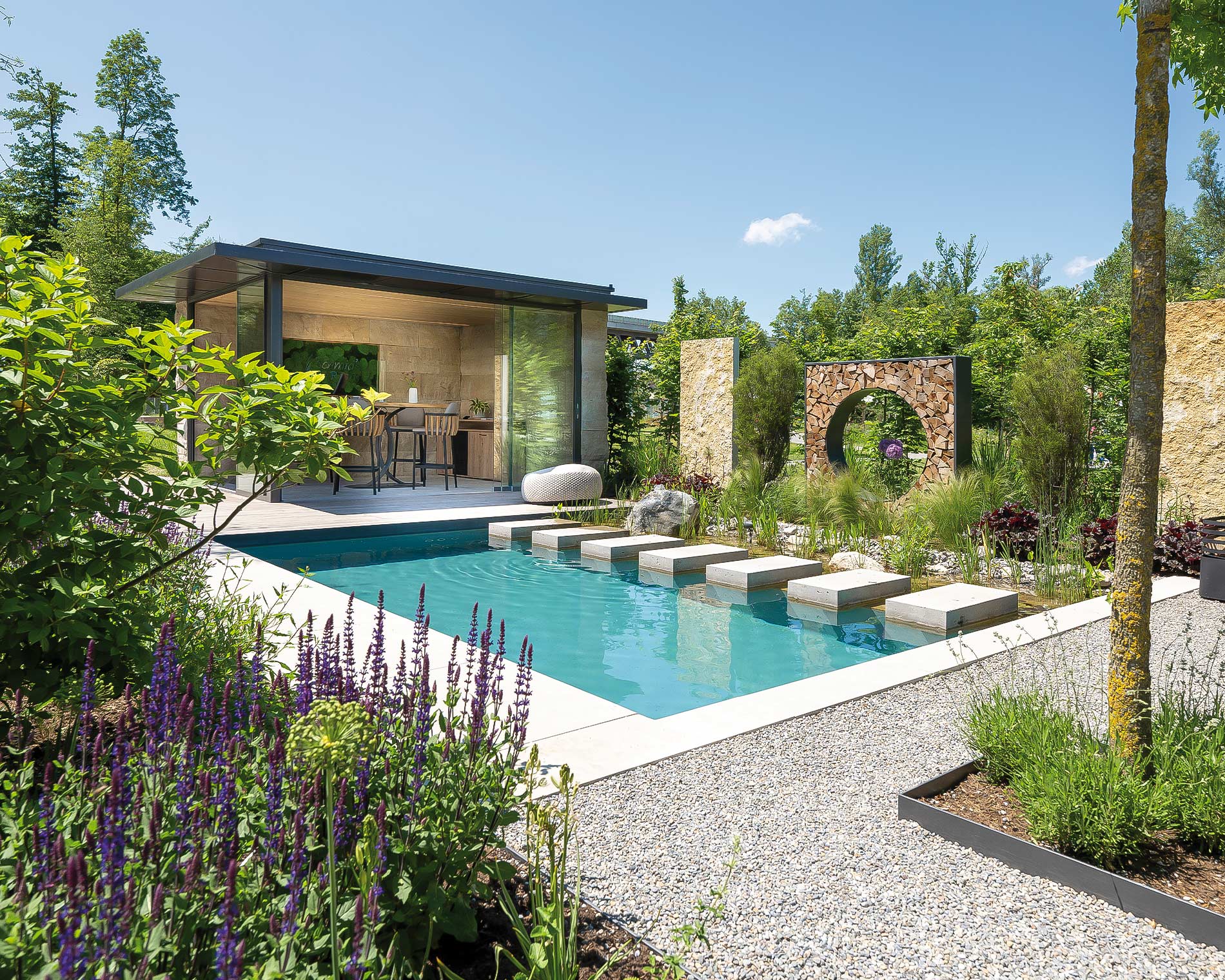 Blick auf den Schaugarten der Landesgartenschau 2024 mit türkisblauem Naturpool mit Tirttsteinen